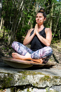 Jóga balanční prkno Funboards s krásnou jogínkou v sedu s rukama v modlitbě
